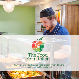 Caterer serving up a hot lunch in a school. The Food Foundation logo.
